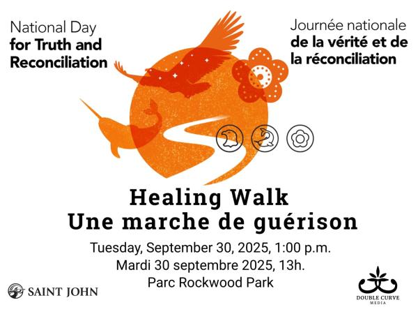 A group of people wearing orange shirts walk on a trail in a park.