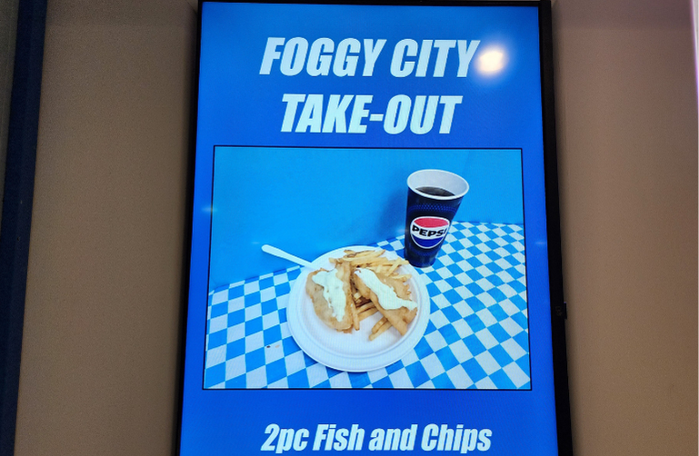 Menu board at Foggy City Takeout in Uptown Saint John featuring smash burgers, fish and chips, and other Maritime comfort food favourites.