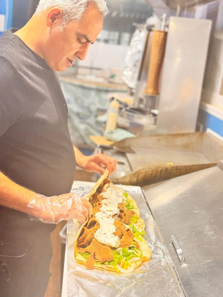 Owner Ahmad Alhaj holding a 32-inch donair at OZE Restaurant