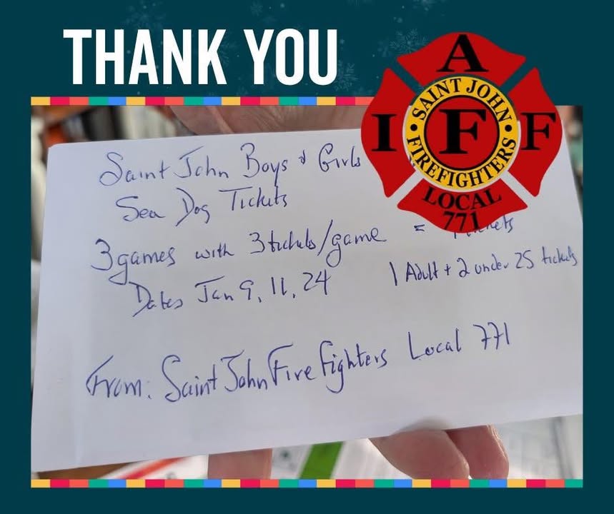 Two Saint John firefighters holding up Sea Dogs season tickets.