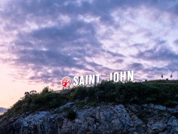 The SAINT JOHN sign lit up at night at Long Wharf.