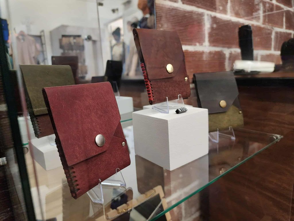Handcrafted leather wallets displayed on stands inside a glass case at Ankar Creative