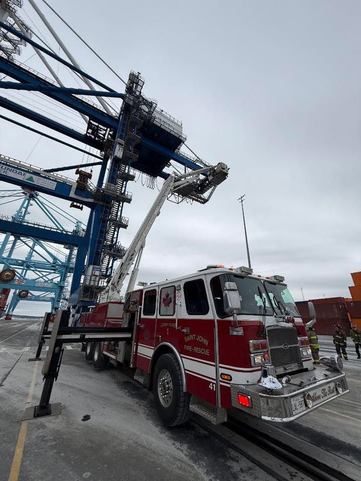 Saint John Firefighters positioning a ladder truck near a crane