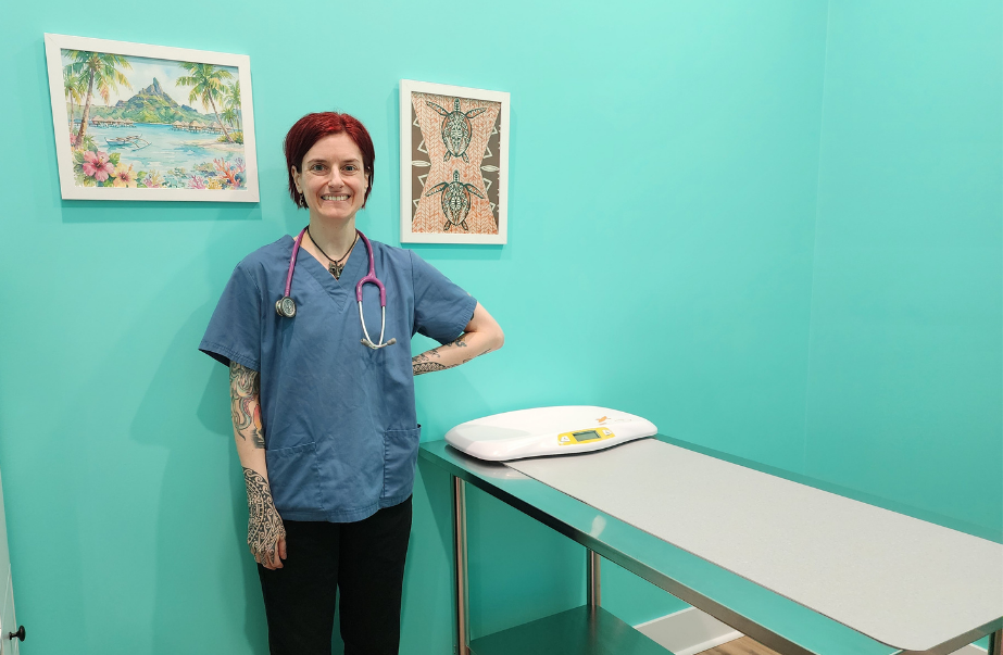 Dr. Alison Messina standing in a turquoise exam room at Uptown Animal Clinic