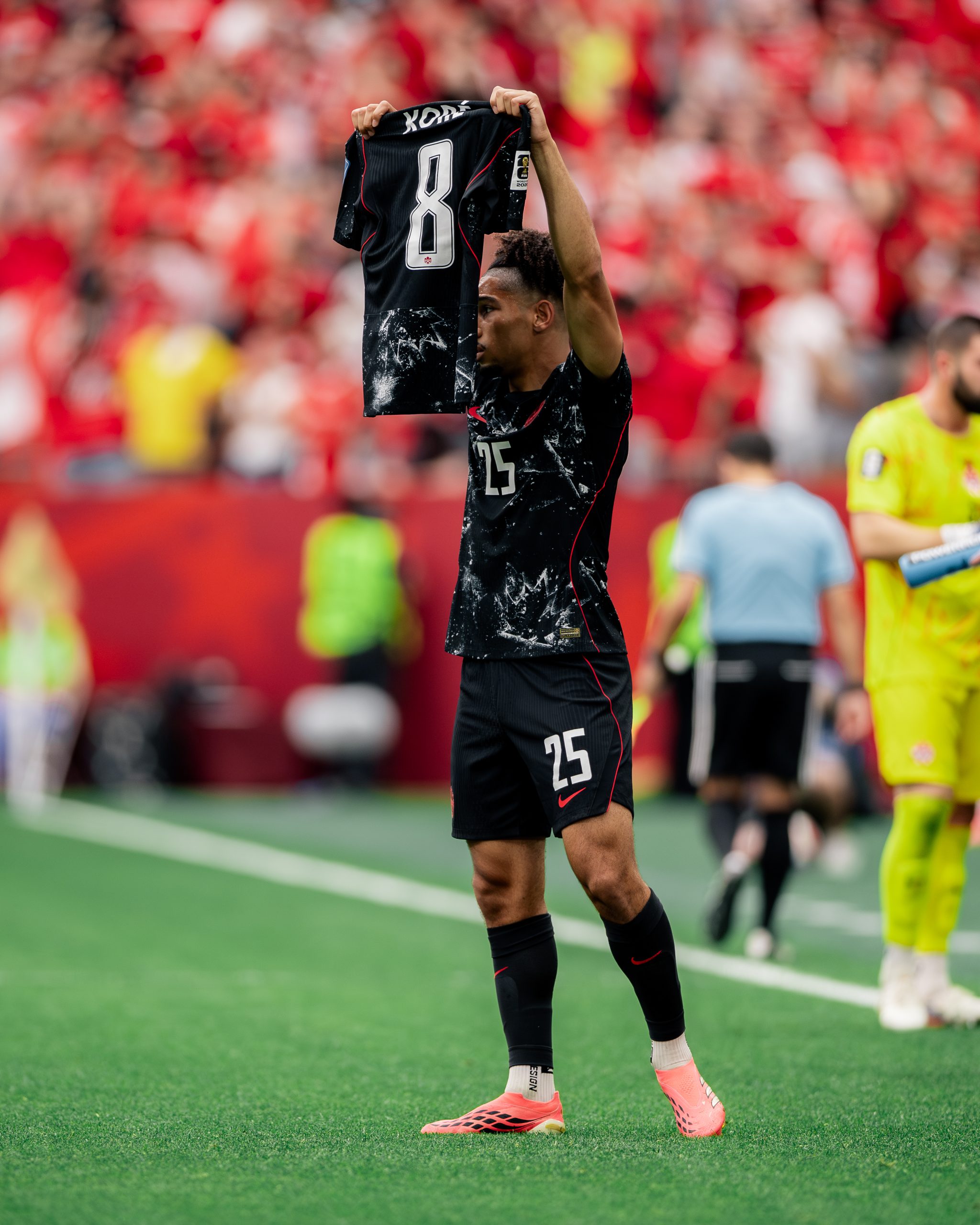 Nathan Saliba holds up an Ismael Kone jersey after scoring
