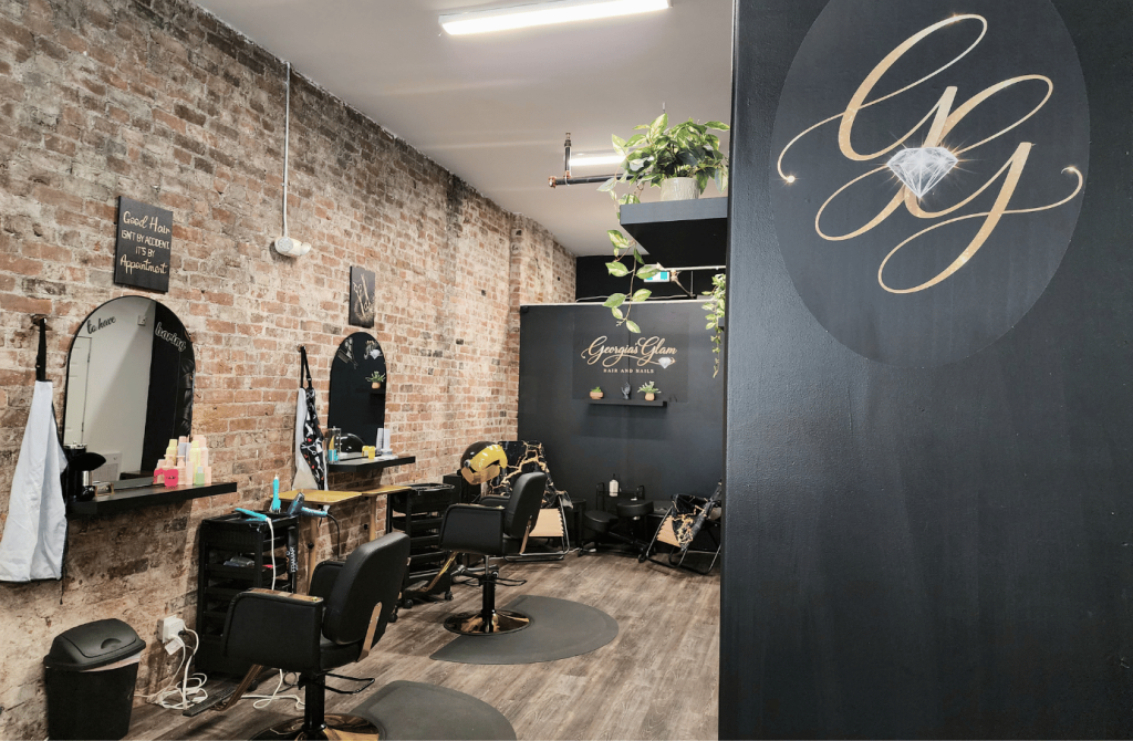 Interior of Georgia's Glam featuring exposed brick walls and styling stations