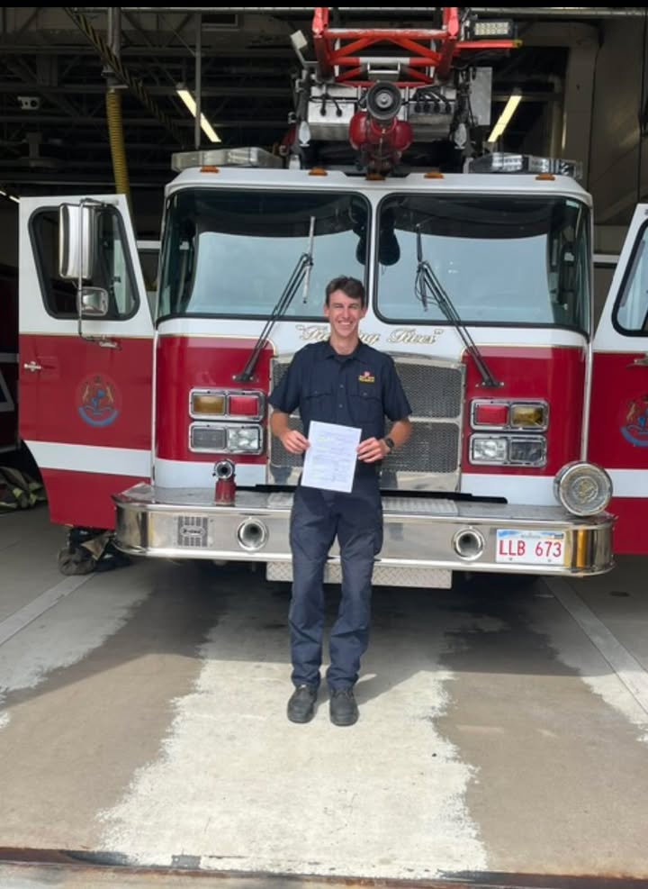 Kaleb Downs standing next to a Saint John fire truck